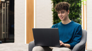 Young smiling man working with laptop office